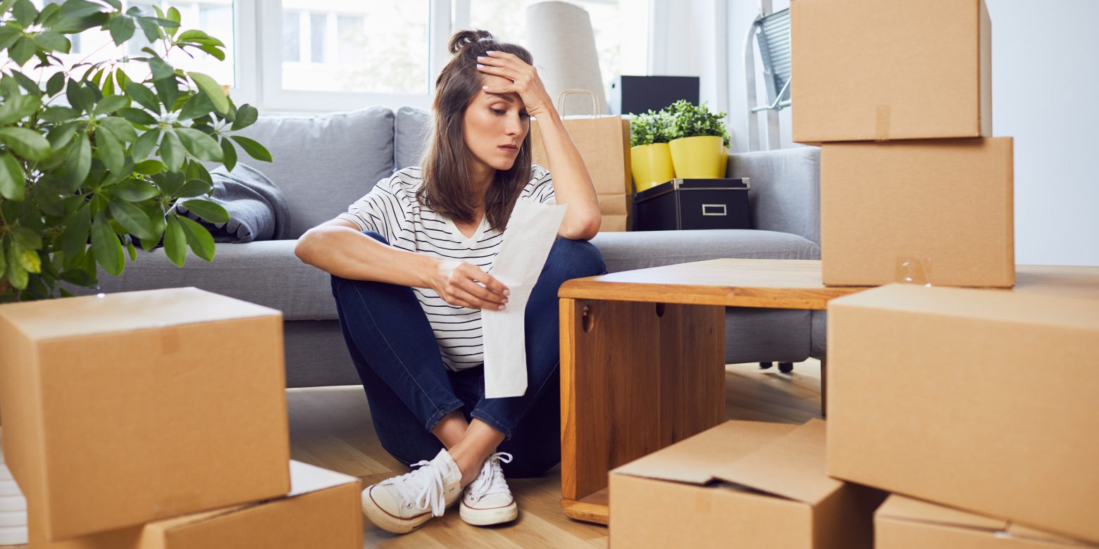 A person is looking at a list of things to do while sitting in a room full of moving boxes. She can cross finding an internet provider off that list.