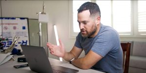 Jon Rettinger talking on a video call on his laptop.