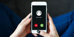 Person holding a phone receiving a call from “robocaller”