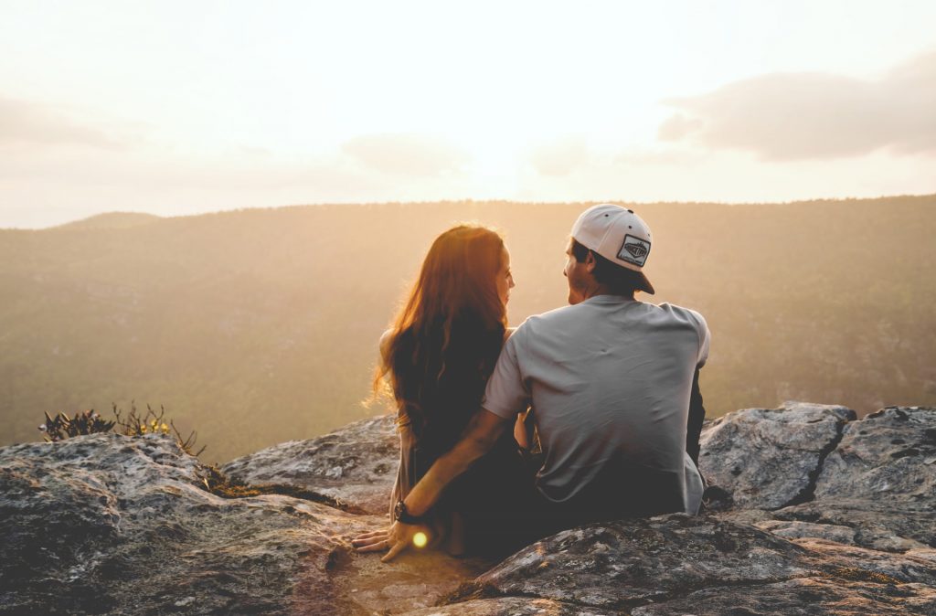 A couple sat looking over a viewpoint in nature.