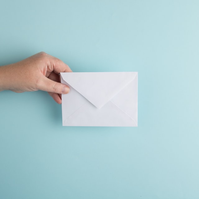 A hand holding an envelope.