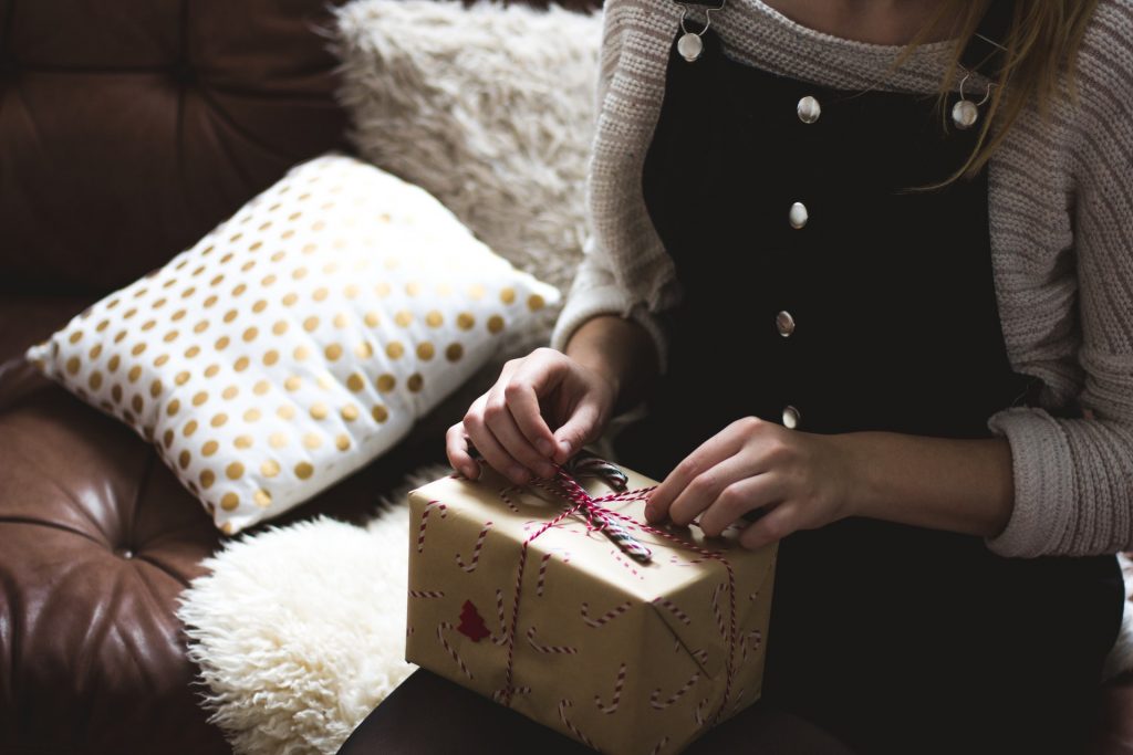 A woman about to open a holiday gift.